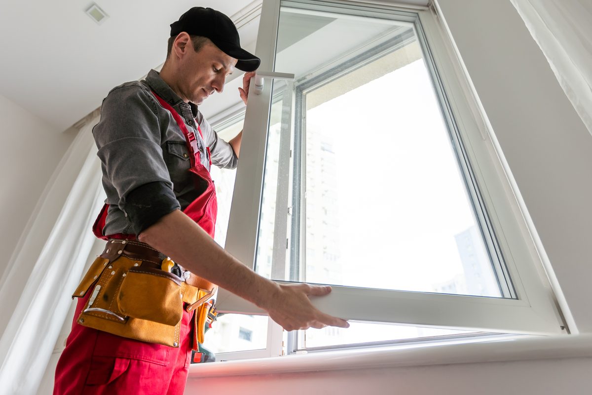Tradesperson fitting and sealing a new window